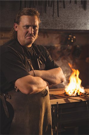 Portrait of blacksmith with arms crossed at work shop Stock Photo - Premium Royalty-Free, Code: 6109-08700808