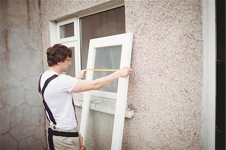 stand house picture wall - Carpenter measuring a door outside home Stock Photo - Premium Royalty-Free, Code: 6109-08700941