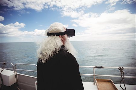 Fisherman using virtual reality glasses on fishing boat Stock Photo - Premium Royalty-Free, Code: 6109-08701038