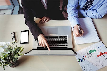 personal organizer - Mid section of businessman discussing with colleague over laptop in office Stock Photo - Premium Royalty-Free, Code: 6109-08701292