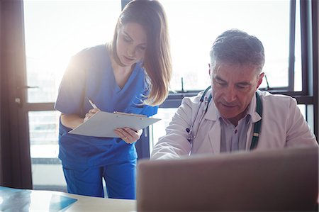 simsearch:6109-08804356,k - Doctor discussing with nurse over laptop at the hospital Stock Photo - Premium Royalty-Free, Code: 6109-08701317