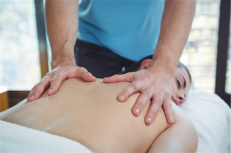 Close-up of physiotherapist giving physical therapy to the back of a female patient in the clinic Stock Photo - Premium Royalty-Free, Code: 6109-08701681