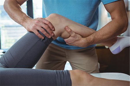 Male physiotherapist giving knee massage to female patient in clinic Foto de stock - Sin royalties Premium, Código: 6109-08701605