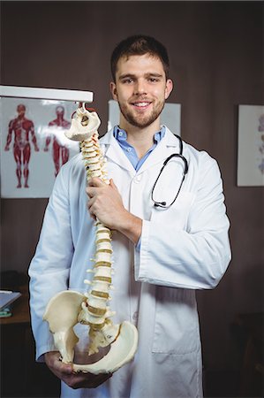 pelvic therapy - Portrait of physiotherapist holding spine model in the clinic Stock Photo - Premium Royalty-Free, Code: 6109-08701749