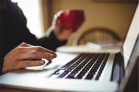 Cropped image of person using laptop at table Stock Photo - Premium Royalty-Free, Code: 6109-08705089