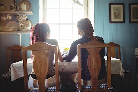 Rear view of couple sitting at table in home Stock Photo - Premium Royalty-Free, Code: 6109-08705111