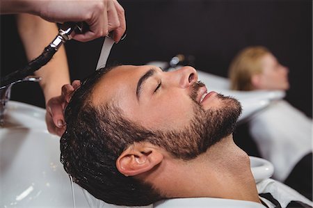 Smiling man getting his hair wash at a salon Stock Photo - Premium Royalty-Free, Code: 6109-08705200