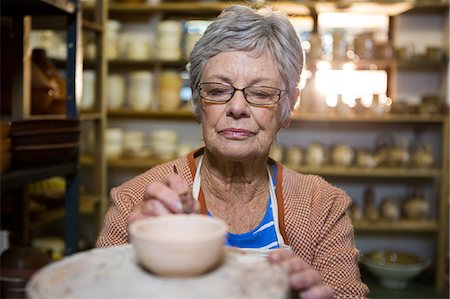 Female potter painting on bowl in pottery workshop Foto de stock - Sin royalties Premium, Código: 6109-08705487