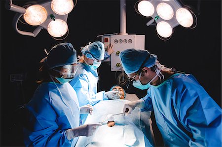 surgical instruments - Surgeons performing operation in operation room at the hospital Stock Photo - Premium Royalty-Free, Code: 6109-08720188