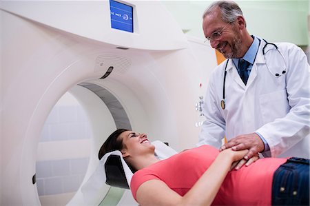 Smiling doctor consoling a patient before an mri scan at hospital Stock Photo - Premium Royalty-Free, Code: 6109-08720123