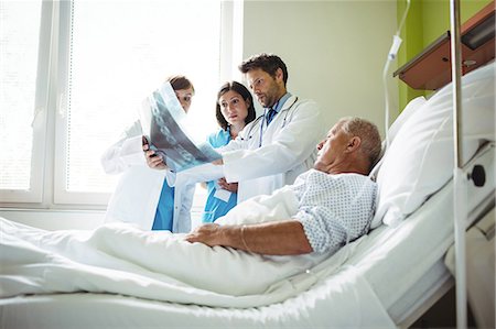 patient nurse talking office - Doctors interacting over x-ray report with patient with patient in hospital Stock Photo - Premium Royalty-Free, Code: 6109-08720217
