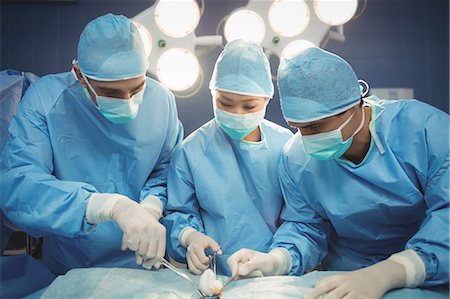doctor with ethnic patient in office - Surgeons performing operation in operation room at the hospital Stock Photo - Premium Royalty-Free, Code: 6109-08720340