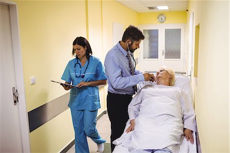 Doctor examining senior patient in hospital corridor Stock Photo - Premium Royalty-Free, Code: 6109-08720322