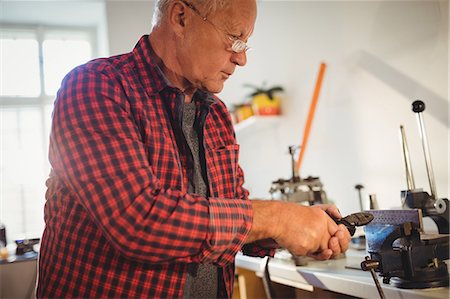 Attentive goldsmith working in workshop Stock Photo - Premium Royalty-Free, Code: 6109-08720451