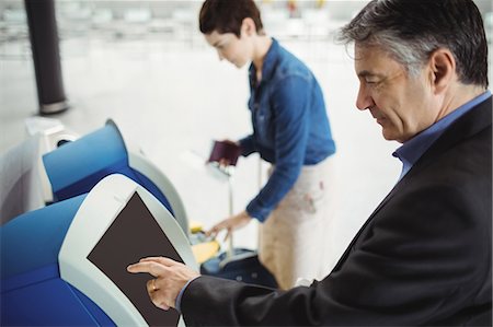 simsearch:400-03938985,k - Businessman using self service check-in machine at airport Foto de stock - Sin royalties Premium, Código: 6109-08722514