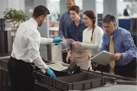passenger at airport - Commuter collecting their bags from the security counter at airport Stock Photo - Premium Royalty-Free, Code: 6109-08722607