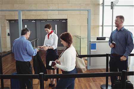 flying happy woman images - Businessman showing his boarding pass at the check-in counter in airport Stock Photo - Premium Royalty-Free, Code: 6109-08722627