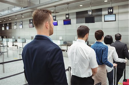 passenger at airport - Passengers waiting in queue at a check-in counter with luggage inside the airport terminal Stock Photo - Premium Royalty-Free, Code: 6109-08722766