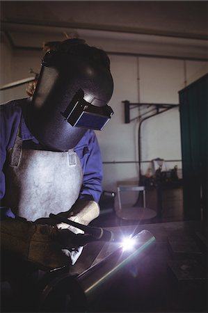 Female welder working on a piece of metal in workshop Stock Photo - Premium Royalty-Free, Code: 6109-08722865