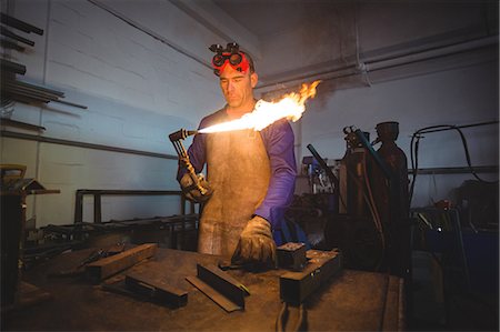 Male welder holding welding torch in workshop Foto de stock - Sin royalties Premium, Código: 6109-08722813