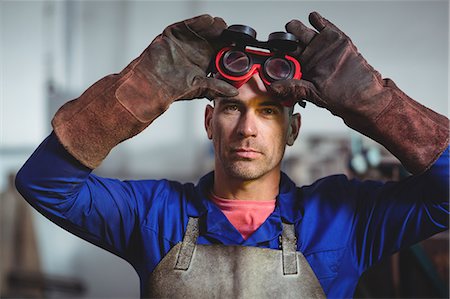 Male welder holding welding goggles in workshop Stock Photo - Premium Royalty-Free, Code: 6109-08722814