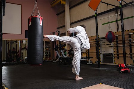 simsearch:400-05908874,k - Man practicing karate with punching bag in fitness studio Stock Photo - Premium Royalty-Free, Code: 6109-08739187