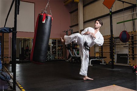 simsearch:400-05908874,k - Man practicing karate with punching bag in fitness studio Stock Photo - Premium Royalty-Free, Code: 6109-08739188