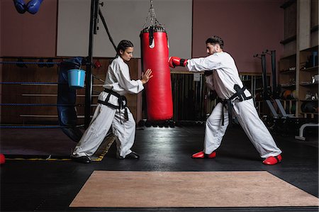 simsearch:400-04347301,k - Man and woman practicing karate with punching bag in studio Photographie de stock - Premium Libres de Droits, Code: 6109-08739198