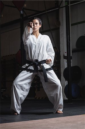Woman practicing karate in fitness studio Stock Photo - Premium Royalty-Free, Code: 6109-08739213