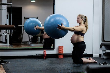 photograph of pregnant women - Pregnant woman exercising with fitness ball in gym Foto de stock - Sin royalties Premium, Código: 6109-08739541