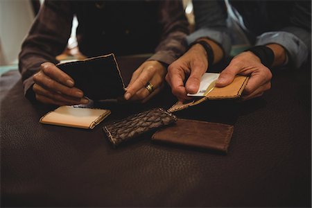 simsearch:693-06379747,k - Craftswomen discussing over a sheet of leather in workshop Stock Photo - Premium Royalty-Free, Code: 6109-08802368