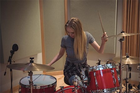 drum (instrument) - Female drummer playing a playing music on drum set in recording studio Stock Photo - Premium Royalty-Free, Code: 6109-08802441