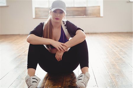 simsearch:6109-08802676,k - Portrait of a pretty woman sitting in hip hop dance in studio Stock Photo - Premium Royalty-Free, Code: 6109-08802666