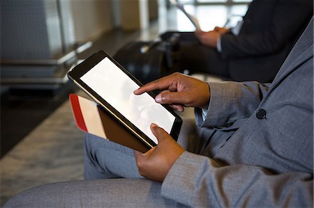 simsearch:400-03938985,k - Mid-section of businessman using digital tablet while sitting at airport terminal Foto de stock - Sin royalties Premium, Código: 6109-08802759