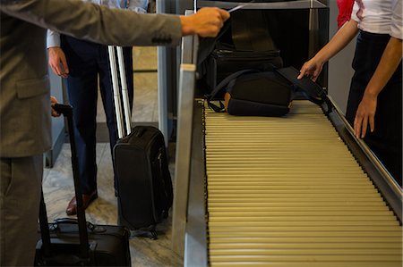 simsearch:400-03938985,k - Female staff checking passengers luggage on conveyor belt in airport Foto de stock - Sin royalties Premium, Código: 6109-08802862