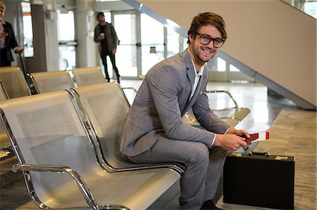 simsearch:400-03938985,k - Businessman with passport, boarding pass and briefcase sitting in waiting area at airport terminal Foto de stock - Sin royalties Premium, Código: 6109-08802834