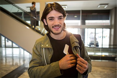 simsearch:400-03938985,k - Happy man keeping passport in his pocket at airport terminal Foto de stock - Sin royalties Premium, Código: 6109-08802839