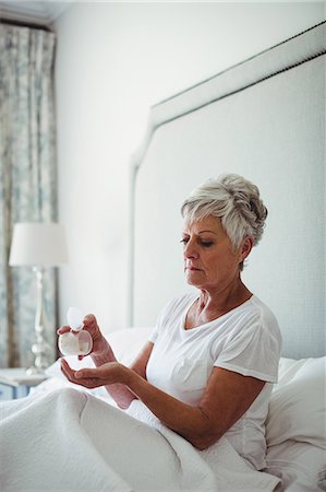 simsearch:6108-05867295,k - Senior woman taking medicine in bedroom at home Stock Photo - Premium Royalty-Free, Code: 6109-08803153