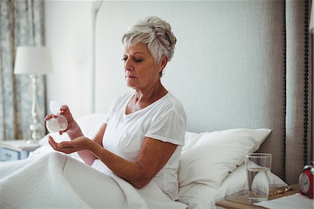 simsearch:6108-05867295,k - Senior woman taking medicine in bedroom at home Stock Photo - Premium Royalty-Free, Code: 6109-08803151
