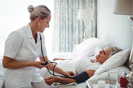 Nurse checking blood pressure of senior woman at home Stock Photo - Premium Royalty-Free, Code: 6109-08803156