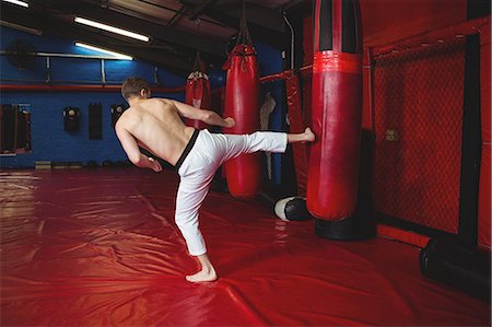 simsearch:649-07238777,k - Karate player practicing kickboxing in fitness studio Stock Photo - Premium Royalty-Free, Code: 6109-08803783