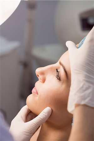 simsearch:6109-08804015,k - Hands of doctor examining womans face for cosmetic treatment at clinic Stock Photo - Premium Royalty-Free, Code: 6109-08803798