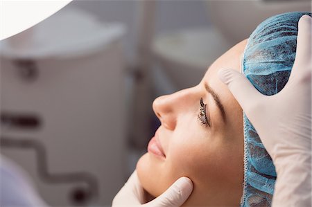 simsearch:6109-08804015,k - Hands of doctor examining womans face for cosmetic treatment at clinic Stock Photo - Premium Royalty-Free, Code: 6109-08803799