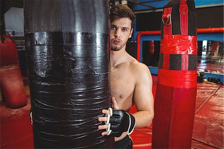 simsearch:649-07238777,k - Portrait of boxer holding a punching bag in fitness studio Stock Photo - Premium Royalty-Free, Code: 6109-08803714