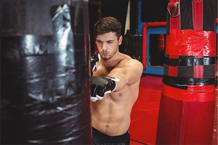 simsearch:649-07238777,k - Boxer punching a boxing bag in fitness studio Stock Photo - Premium Royalty-Free, Code: 6109-08803715
