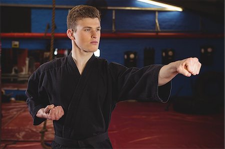 Karate player performing karate stance in fitness studio Stock Photo - Premium Royalty-Free, Code: 6109-08803726