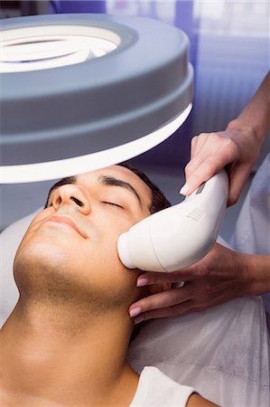 simsearch:6109-08804015,k - Man getting a facial massage for cosmetic treatment at clinic Stock Photo - Premium Royalty-Free, Code: 6109-08803813