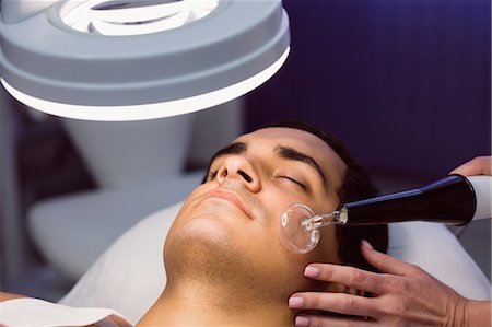 simsearch:6109-08804015,k - Man getting a facial massage for cosmetic treatment at clinic Stock Photo - Premium Royalty-Free, Code: 6109-08803815