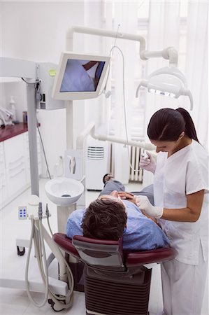 dentist with patient in exam room - Female dentist examining patient in dental clinic Stock Photo - Premium Royalty-Free, Code: 6109-08803989