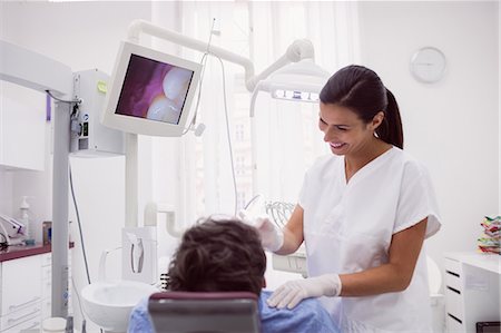 dentist with patient in exam room - Female dentist examining patient in dental clinic Stock Photo - Premium Royalty-Free, Code: 6109-08803990